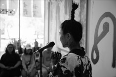 Cui talking on a mic in front of people